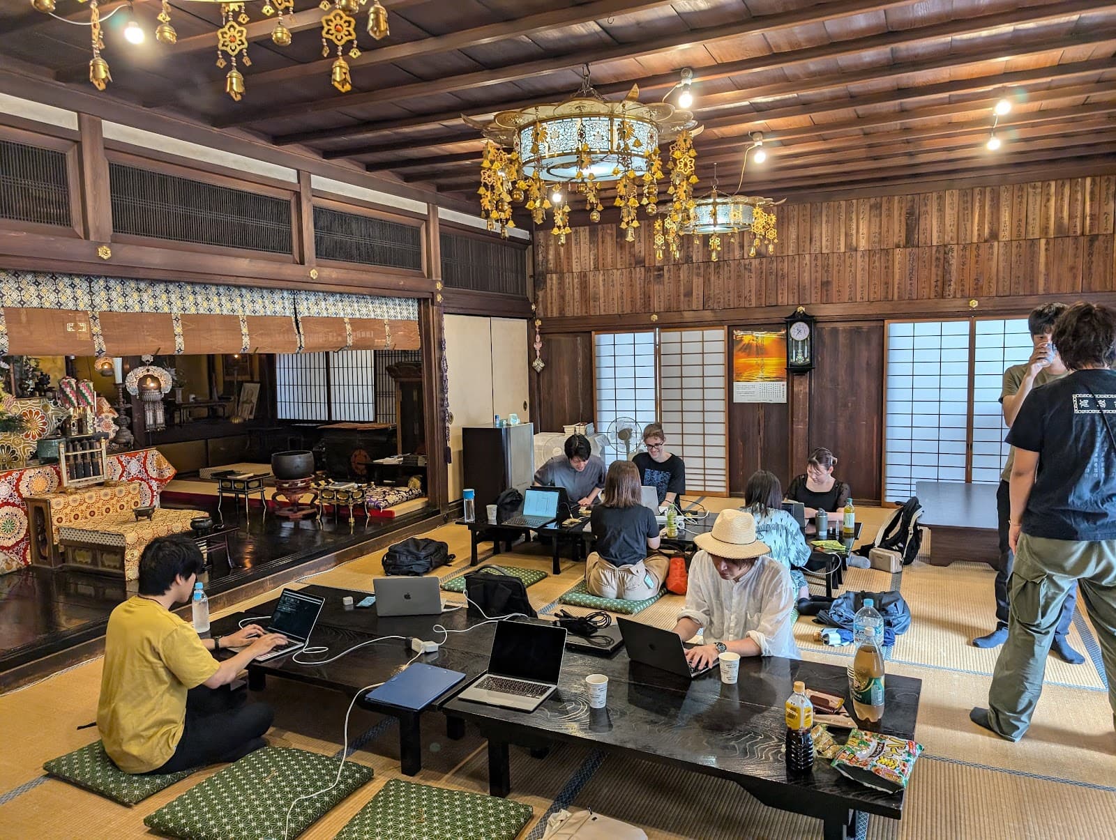 お寺の本堂でノートPCを開いて作業する「みやこでIT」の参加者たち